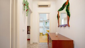 A hallway with a wooden dresser, a mirror with a garland, and a door leading to a bathroom. - Oasi Villa Anthea Apartment with Exclusive-Use Pool, Wi-Fi, and Air Conditioning (Monopoli)