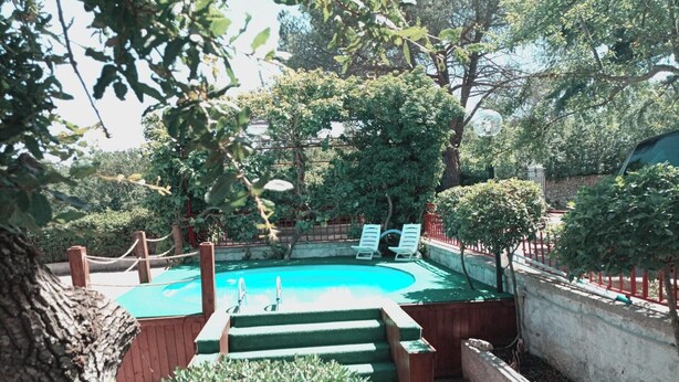 A swimming pool surrounded by trees and a wooden deck. - Oasi Villa Anthea Apartment with Exclusive-Use Pool, Wi-Fi, and Air Conditioning (Monopoli)