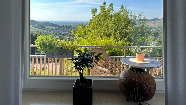 Un balcone con vista su un paesaggio verde e un recinto in legno.