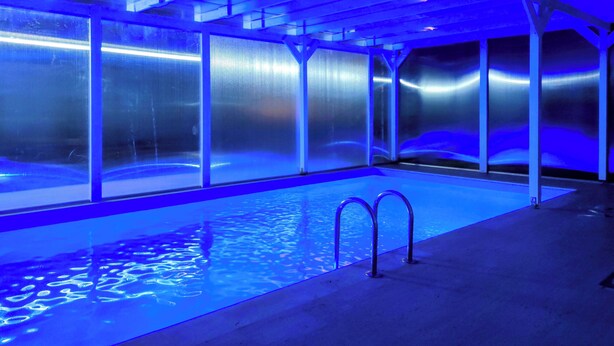 An indoor swimming pool with clear glass walls and a blue-lit ceiling. - Şilede doğa içinde denize yakın kapalı ısıtmalı havuzlu şömineli barbekülü villa (İmrenli)
