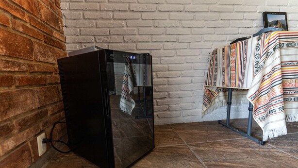 A room with a brick wall, a black cabinet, and a patterned tablecloth. - Anana Casa SK Villa With Garden Family-friendl (Chapala)
