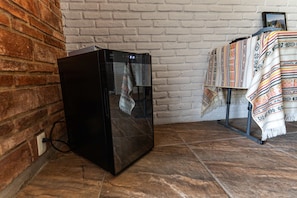 Una habitación con una pared de ladrillo, un armario negro y un mantel estampado.
