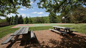 An outdoor basketball court with a picnic table in the foreground. - Charming Condo | Ski-in/Ski-out + Pool Access (Champion)