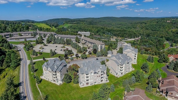 Vue aérienne d’un quartier résidentiel comprenant de nombreux immeubles à étages, des routes et de la végétation environnante.