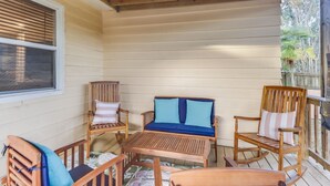 Un terrazzo in legno con un divano, sedie e un tavolo.