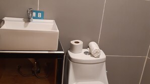 A bathroom with a white sink, a toilet, and a trash bin. - Rosaelena b&b tours and experiences with transportation included 7persons (Cusco)