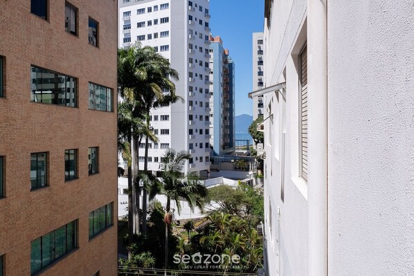 Un edificio de varios pisos con fachada de ladrillo, ventanas amplias y una pared exterior blanca.