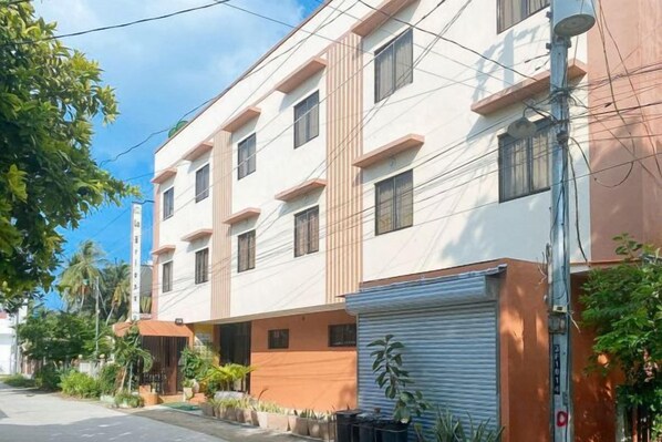 A multi-story building with a flat facade, large windows, and a gated entrance.