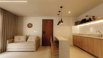 A modern kitchen with a wooden countertop, a built-in bench, and pendant lighting.