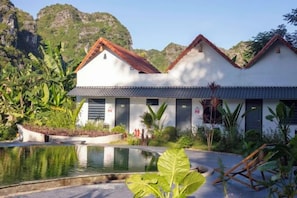 A two-story building with a pool, surrounded by tropical vegetation. - Trang An Ecorest Resort & Spa (Hoa Lu District)