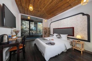 A modern bedroom with a large bed, a desk, and a television. - Trang An Ecorest Resort & Spa (Hoa Lu District)