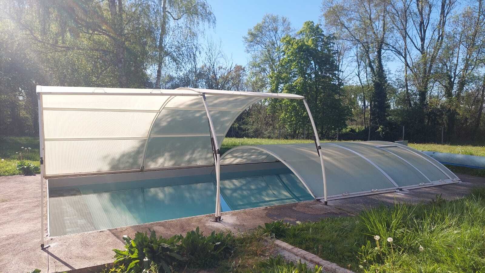 A swimming pool with a glass enclosure and a metal frame.