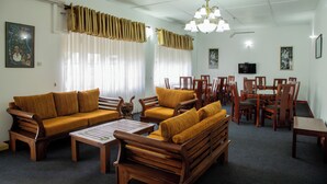 A living room with a sofa set, wooden chairs, a coffee table, and a dining table with chairs. - Cozy Nest Kandy Villa (Kandy)