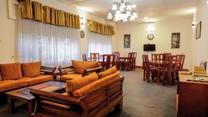 A living room with a sofa set, wooden chairs, a dining table, and a chandelier. - Cozy Nest Kandy Villa (Kandy)