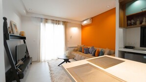 Ein modernes Wohnzimmer mit einer Couch, einem Couchtisch und einem Fernseher.