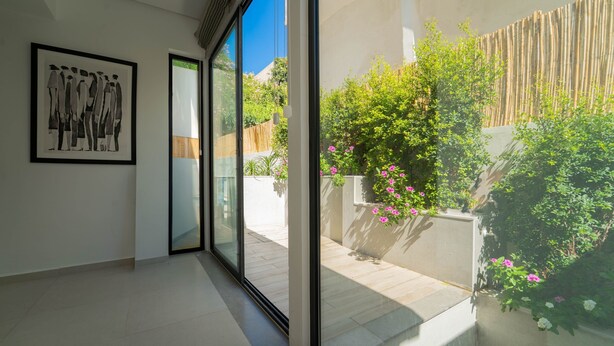 Un intérieur moderne avec une grande porte-fenêtre coulissante donnant sur un jardin.