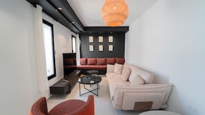 A modern living room with a sofa, armchairs, a coffee table, and a TV. - Aurora La Marsa Jacuzzi Modernit Charme (La Marsa)