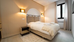 A modern bedroom with a bed, bedside tables, and a large window with curtains. - Aurora La Marsa RDC Modernit Charme (La Marsa)