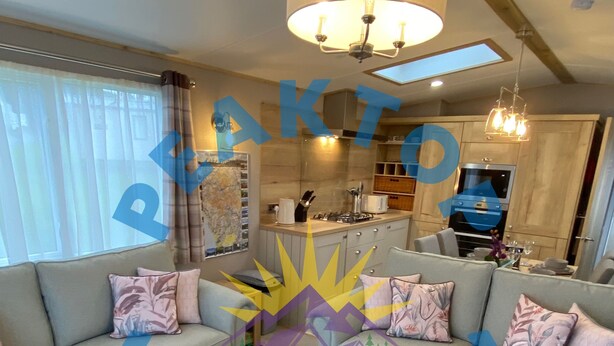 A modern living room with two sofas, a coffee table, and a kitchen in the background.