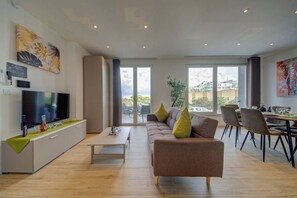 Un salon moderne avec un canapé, une table basse et un coin repas.
