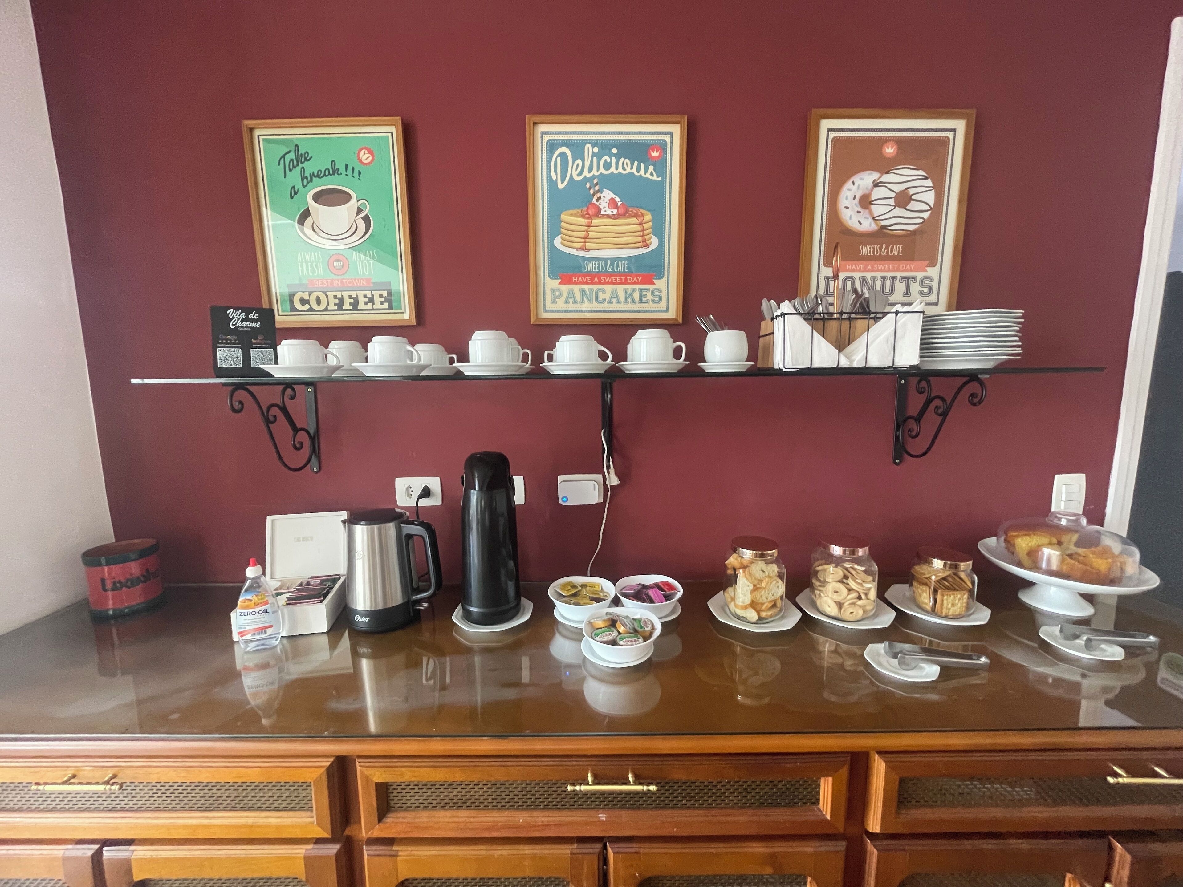 A breakfast buffet with coffee, pastries, and donuts.