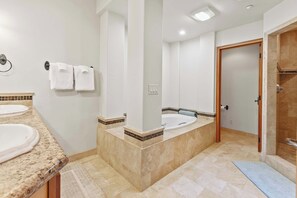 Un baño con dos lavamanos, una bañera grande y una zona de ducha.