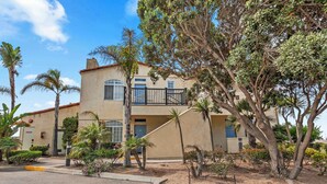 A two-story building with a balcony, surrounded by palm trees and other vegetation. - Eye Sea (Oceano)