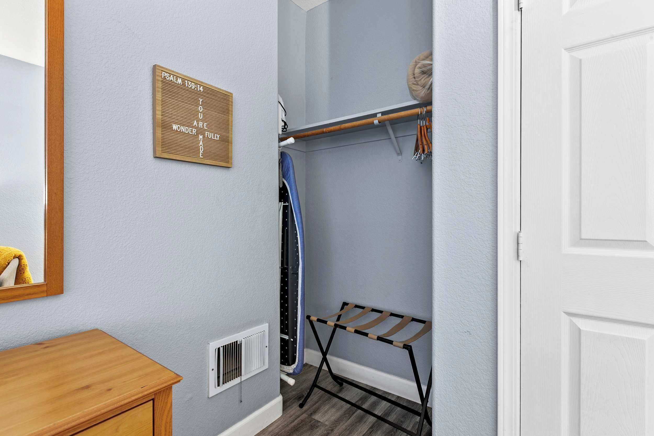 A bathroom with a wooden vanity, a towel rack, a wall-mounted mirror, and a towel hanging on the rack.