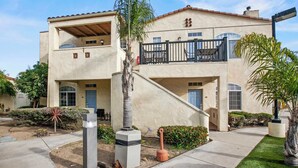 A two-story building with a balcony, a staircase, and a well-maintained garden. - The Seaside Sunshine (Oceano)
