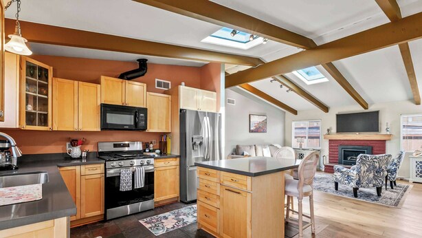 A modern kitchen with wooden cabinets, stainless steel appliances, and a skylight. - The Bay Escape (Baywood-Los Osos)