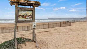 A wooden signboard with a map and information about Beach Wrack. - Coastal Cutie (Oceano)
