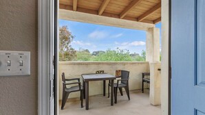 An outdoor patio with a table and chairs, a power outlet, and a view of the surrounding landscape. - Coastal Cutie (Oceano)