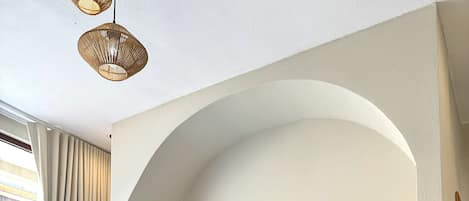 Una sala de estar moderna con un sofá, cojines, una mesita de centro y una planta en maceta.