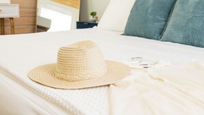 Una cama con un sombrero de paja y una camisa blanca.