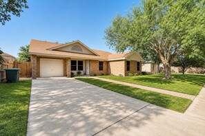 A residential house with a garage, a front lawn, and a tree. - Covered Patio + Grill • Backyard • 2Mi to Basilica (San Juan)