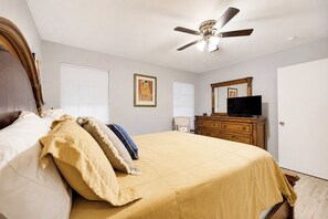 A bedroom with a bed, a dresser, a television, and a ceiling fan. - Covered Patio + Grill • Backyard • 2Mi to Basilica (San Juan)