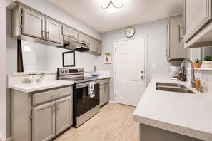 A kitchen with a built-in oven, stainless steel appliances, a double sink, and light gray cabinetry. - Covered Patio + Grill • Backyard • 2Mi to Basilica (San Juan)