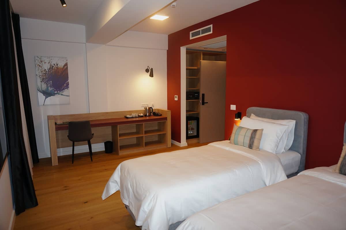 Une chambre avec deux lits, un bureau, une chaise et une armoire.