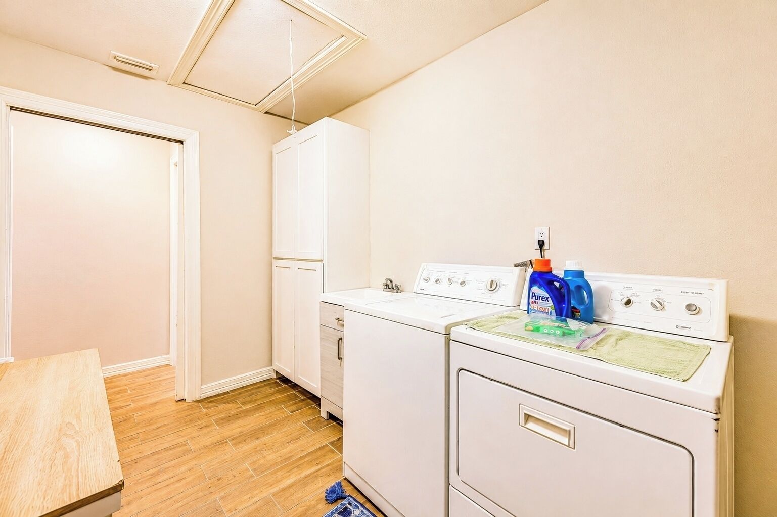 A laundry room with a washing machine, dryer, and a cabinet.