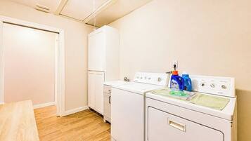 A laundry room with a washing machine, dryer, and a cabinet.
