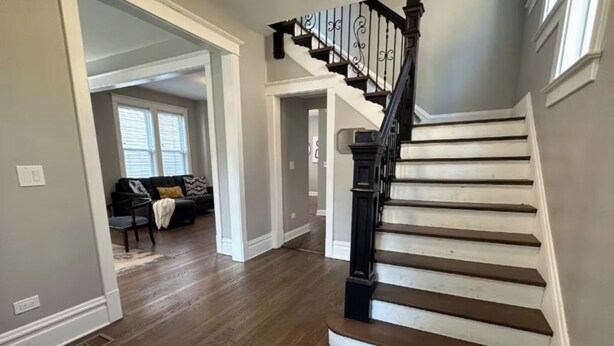 A staircase with a black handrail leading to an upper floor. - Near Lake and Museum • Modern • Game Area (Chicago)