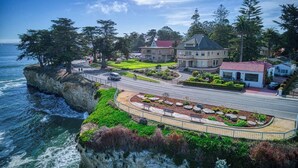 Une propriété située sur la côte, comprenant une grande maison, un bâtiment plus petit et un jardin aménagé.