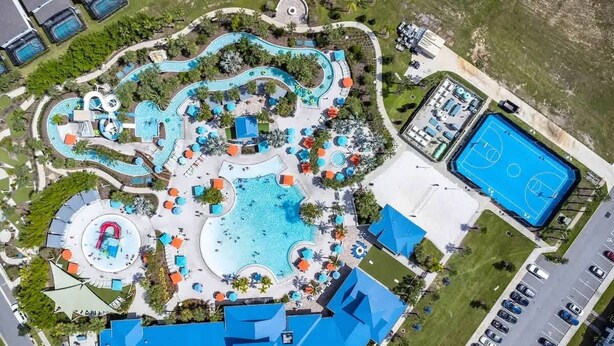 Vista aérea de un resort con múltiples piscinas, una cancha de baloncesto y diversas zonas de descanso.