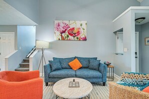 A living room with a blue sofa, orange armchair, and a round coffee table. - Mins to Beach - Pool - Screened Porch-Free Parking (Horry County)