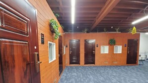 Un pasillo con paredes y puertas de madera, suelo alfombrado y un letrero que indica 'zona de silencio'.