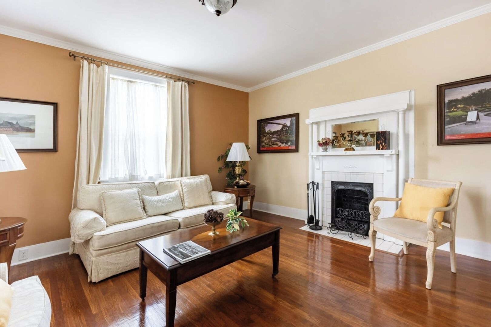 Una sala de estar con sofá, mesa de centro, chimenea y sillón.