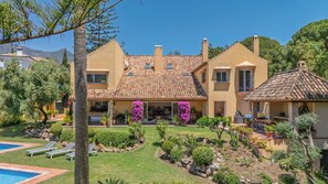 Eine mediterrane Villa mit Ziegeldach, Schwimmbad und gepflegtem Garten.