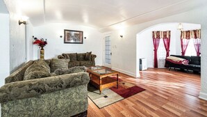Un salon spacieux avec un grand canapé, une table basse et une cheminée.