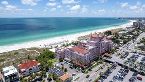Ein Küstenhotel mit mehreren Gebäuden, einem Strand und einem Parkplatz.
