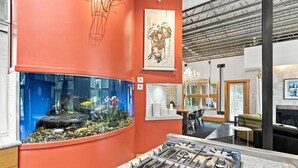 Una cocina moderna con un acuario grande, comedor y chimenea.